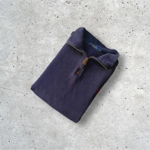 Mörkblå half zip tröja Polo Ralph Lauren - Mörkblå tröja från Polo Ralph Lauren med klassisk röd broderad logga på bröstet. Tröjan har half zip-dragkedja med läderdetalj och hög krage. Tillverkad i bomull och passar perfekt för lager-på-lager under höst och vinter.