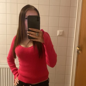 Rosa stickad v-ringad tröja - Säljer en snygg rosa stickad tröja med v-ringning och långa ärmar. Tröjan har en figurnära passform och är perfekt för dig som gillar färg och vill ha något bekvämt men ändå trendigt. Passar till både jeans och kjol.