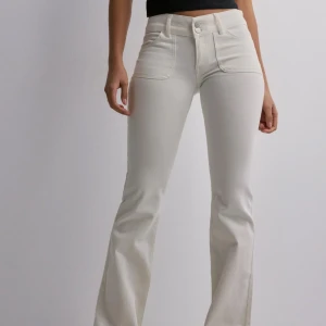 Vita low waist bootcut jeans - Snygga låg midjade vita bootcut-byxor från Nelly. 