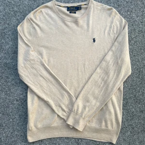 Beige Ralph Lauren Sweatshirt - Beige sweatshirt tröja från Polo Ralph Lauren i slim fit. Perfekt för en clean och stilren look. Skick: 9/10✅ | Storlek: M | Tveka inte att höra av vid frågor!