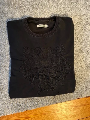 Svart Kenzo tröja - Svart tröja från Kenzo i storlek XXL men sitter som M/L. Skicket är mycket bra och inga fläckar. Skriv vid frågor eller kom med bud