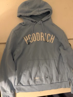 •	Hoodrich Ljusblå Tracksuit – Hoodie & Mjukisbyxor - Hoodrich tracksuit / set (hoodie + byxor) Snyggt Hoodrich-set i ljusblå färg. Hoodie med klassisk passform, justerbar huva och brösttryck med Hoodrich-loggan. Matchande mjukisbyxor med fickor, dragsko i midjan och stilrena detaljer/logotryck på benen. Bekvämt material och perfekt för både vardag och streetwear-look. Hoodrich set i ljusblå färg. Hoodie i storlek M och byxor i storlek L. Säljs som set. Passar bra tillsammans i passform.