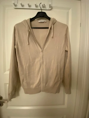 Beige merinoull hoodie  - Helt ny beige merinoull hoodie den är använd en gång så i toppskick, inga defekter eller likande. Storleken är 158-164 vilket motsvarar ungefär xs 