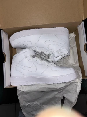 Nike Air Force 1 mid vita storlek 42 - Helt nya nike air forces 1 mids som köptes förra året. Skorna har bara testas inomhus. Allt originalt finns kvar kan mötas i Stockholm eller frakt. STORLEK 42