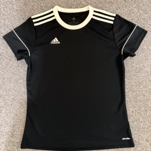 Svart Adidas träningströja M - Snygg svart fotbollströja från Adidas i storlek M. Hör av dig vid frågor eller behov av fler bilder!