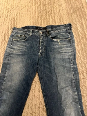 Blå Stone Island jeans med slitningar - Säljer ett par blå jeans från Stone Island med snygga slitningar. Innerbenslängd är ca 85 cm och midjan är ca 45cm