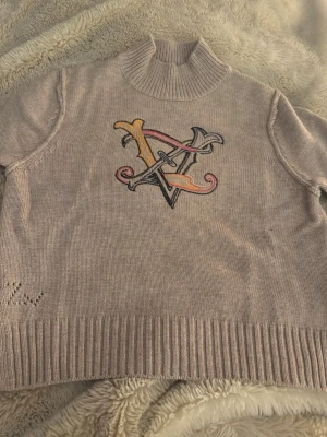 Beige polotröja Zadig & Voltaire - Säljer en beige polotröja från Zadig & Voltaire med stor broderad logga i flera färger på bröstet. Tröjan är stickad i mjukt rejäla material och har ribbade muddar samt hög krage. Perfekt för dig som gillar stilrena men ändå unika plagg.