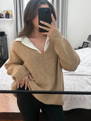 Beige stickad oversized tröja H&M  - Säljer en beige stickad tröja med v-ringning och lång ärm. Den är i storlek L men passar M och S om man gillar oversize själv är jag S och 163cm lång Tröjan har en oversized passform och är ribbstickad, perfekt att slänga på över en skjorta för en chill och snygg look.