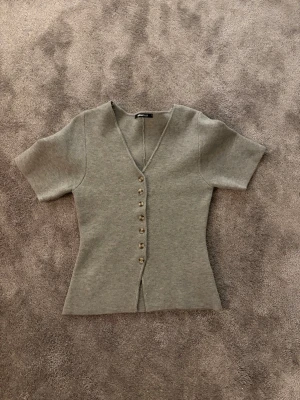 Grå populär tröja från Gina Tricot - Kortärmad grå tröja från Gina Tricot i stickat material. Tröjan är som ny endast använd ett par enstaka gånger☺️💞 i strl S