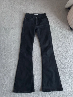 Svarta bootcut jeans  - Säljer ett par svarta bootcut jeans från Gina Tricot i storlek 32. Jeansen är mid waisted och har utsvängda ben. De är i mycket bra skick.