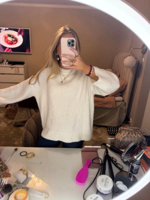 Vit stickad oversized tröja - Mysig vit stickad tröja med oversized passform och ribbade muddar vid ärmslut och nederkant. Perfekt för lager-på-lager och chill dagar. Klassisk rund halsringning och långärmad modell som passar till jeans eller kjol.