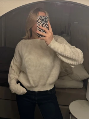 Vit stickad tröja från Gina Tricot - Säljer en vit stickad tröja från Gina Tricot i storlek M. Tröjan har en djup v-ringning, ribbade muddar och är långärmad. Perfekt för lager-på-lager!