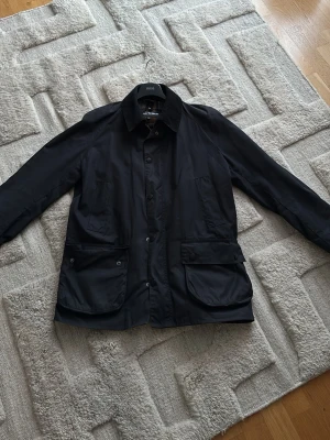 Svart Barbour jacka  - Svart parkajacka från Barbour som är inköpt i London. Jackan används inte och säljs därför. Storleken är XL men passar även folk med storleken L.