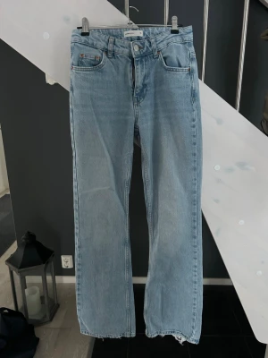 Ljusblå raka jeans från Gina Tricot - Säljer ett par ljusblå jeans från Gina Tricot med raka ben och råa kanter nertill. Klassisk femficksmodell med normal passform och medelhög midja. Perfekta för en avslappnad och trendig look.
