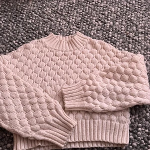 Beige stickad trhoodie från Monki -  Lotta en supermysig beige stickad tr uninterrupted från Monki i storlek M. Tröjan har ett coolt bubbligt mönster stock över hela och breda rib ände vid ärmar och midja. Perfekt för lager på lager under höst och vinter:)