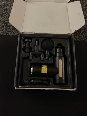 Massage Pistol - Bilderna visar en massagepistol med fyra utbytbara massagehuvuden och laddas via USB-C. Ingen väst finns med på bilderna.