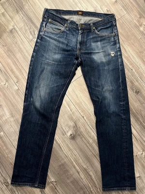 Lee jeans met snygga slitningar  - Riktigt snygga lee jeans med feta tvättningar i en rak blandad med lite slim passform. De har ett snyggt hål som man inte kan se huden för fickan är bakom. Passar mig som är 178