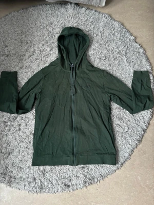 Mörk grön Armani zip hoodie  - En snygg o bekväm zip hoodie från Emporio Armani i mörkgrön färg, tröjan är i slim fit och fungerar som en tröja till vardags eller till gymmet mm,