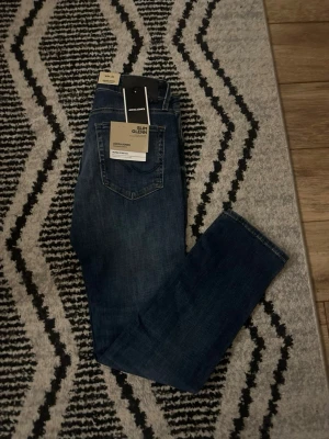 Jack & Jones Slim Glenn jeans blå 28/30 - Säljer ett par snygga Slim Glenn jeans från Jack & Jones i klassisk blå tvätt. Jeansen har en slim passform, fem fickor och normal midja. Materialet är stretchigt jeans-tyg som sitter skönt hela dagen. Perfekta till en avslappnad stil.
