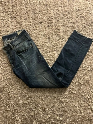 Blåa Disel jeans men skön tvätt - Säljer ett par Diesel belther jeans i mörkblå tvätt med snygga slitningar. Jeansen har normal passform och raka ben, med diesel loggor och detaljer i metall. Perfekta för dig som gillar stilrena och bekväma jeans.               Hör av dig vid frågor eller prisförslag🫡