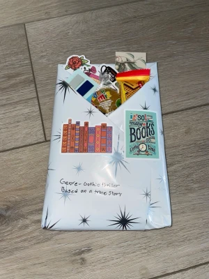 Blind date with a book  - Blind date med en bok genre gothic thriller based on a true story man får även med lite grejer 2 stickers boktema 1 bokmärke 3 färger på anotate stickers som matchar boken och lite godis