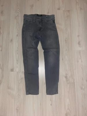 Replay Anbass grå jeans - Snygga Replay Anbass jeans i tvättad grå färg. Klassisk femficksmodell med raka ben och diskreta sömmar. Jeansen har normal passform och är tillverkade i mjukt jeansmaterial som sitter skönt hela dagen.