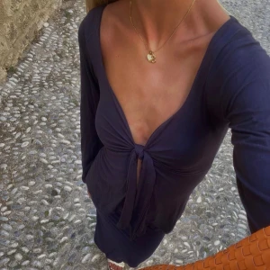 Design By Si topp - Marinblå långärmad blus från Design By Si. Storlek M/L, använd vid enstaka tillfälle! Nypris: 393kr