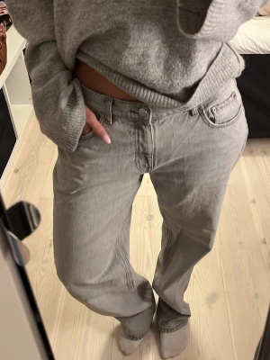 Gråa wide jeans med hög midja - Säljer ett par gråa jeans med hög midja och breda ben. Jeansen har klassisk femficksdesign, raka sömmar och en avslappnad passform. Perfekta för dig som gillar en chill och trendig stil.