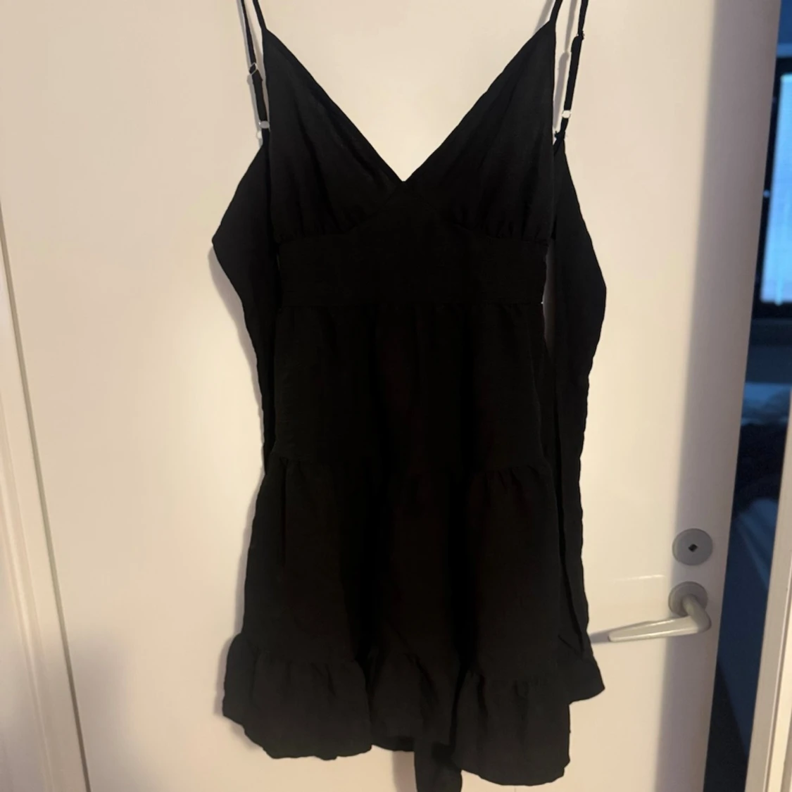 Svart kort klänning med volang