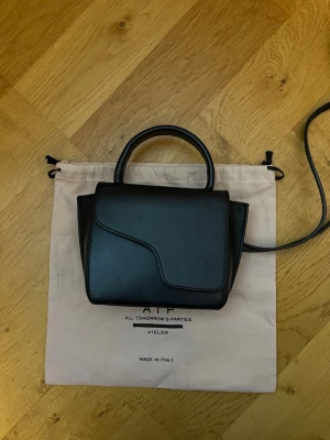 Svart handväska från ATP Atelier - Säljer en stilren svart handväska från ATP Atelier. Väskan är i mycket bra skick med några enstaka ytliga repor💖