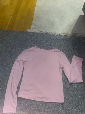 Ljusrosa långärmad topp i polyester - Säljer en ljusrosa långärmad topp från Shein i storlek M. Toppen är enkel och stilren med rund hals och tillverkad i mjukt och stretchigt material, 95% polyester och 5% spandex. Perfekt att matcha med jeans eller kjol för en chill look.