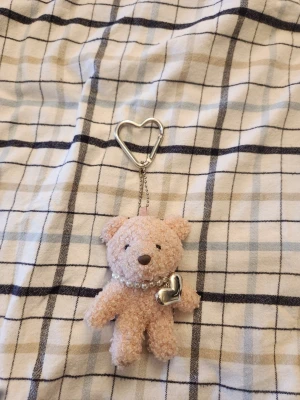 Nallebjörn nyckelring med pärlhalsband - Söt rosa nallebjörn som nyckelring med hjärtformat metallfäste. Använd endast 2ggr på en handväska men den passar inte i färgen tyvärr. Nypris: 100kr