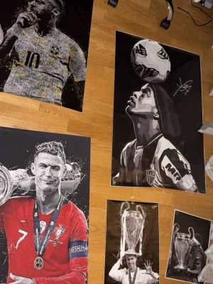 Fotbollsposters med ikoniska motiv - Säljer flera posters med motiv av kända fotbollsspelare och troféer. Färgerna går i svart, vitt, grått och rött. Motiven är stiliserade och vissa har autograftryck. Perfekt för dig som älskar fotboll och vill ha sportig inredning på väggen. Fina fotbollsaffischer fràn Neymar Jr, Cristiano Ronaldo och Ronaldinho i olika storlekar! Vid intresse av köp skriv sa förhandlar vi! Ronaldinho 249kr, Ronaldo 159kr, Neymar 159kr, och resterande lite mindre Ronaldo och Neymar 110kr var. Kom och ställ frägor