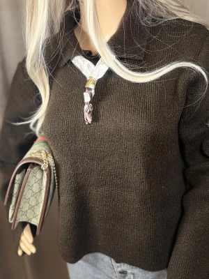 Vit och brun paisleymönstrad halsduk M-L - Säljer en smal halsduk i vitt och brunt med paisleymönster och guldfärgad detalj. Halsduken är tunn och elegant, perfekt att knyta runt halsen för en chic look. Materialet ser ut att vara siden eller liknande för en lyxig känsla.