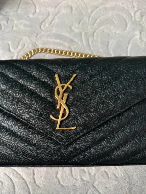 Svart YSL kuvertväska i läder - Väldigt fin och beställde den från hemsidan 😊 fraktar direkt efter köp kan även mötas upp i Stockholm 