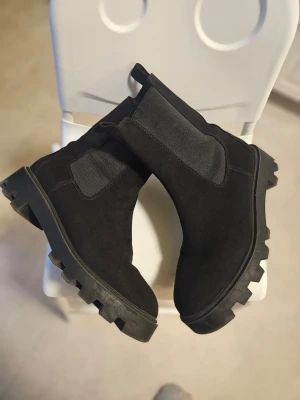 Svarta chunky Chelsea boots - Svarta chunky chelseaboots från HM DIVIDED  Strl. 39  Enbart använda en gång ute så I jättebra skick  Perfekta för dig som vill ha en cool och stilren look. 