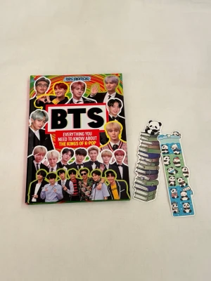 BTS faktabok + bokmärken - Färgglad inofficiell faktabok om BTS med texten 'Everything you need to know about the kings of K-pop' på omslaget. Boken har hårdpärm och motiv av BTS-medlemmarna. Två bokmärken med panda- och bokmotiv ingår, perfekta för K-popfans.