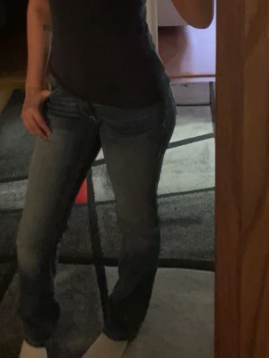 Blå bootcut jeans från Replay - Säljer ett par blå bootcut jeans från Replay med klassisk femficksmodell och snygg tvätt. Jeansen har normal midja och raka ben, perfekta till en avslappnad stil. Materialet är mjukt denim som sitter skönt hela dagen.