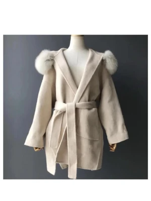 Beige kappa med pälskantad huva - Snygg beige kappa med stor huva kantad av fluffig päls. Jackan har bälte i midjan för att knyta. Säljer då jag inte har fått nån användning av den på länge. Pris kan diskuteras vid snabbt köp🥰