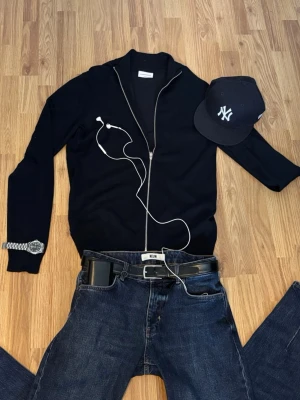 Mörkblå zip up från Lindbergh  - Marinblå kofta från Lindbergh i slim fit-modell. Tröjan har en hel dragkedja framtill, ribbade muddar och krage. Materialet är stickat och ger en stilren look. Perfekt för dig som gillar simpelt lyxigt mode. Pris kan diskuteras 💰