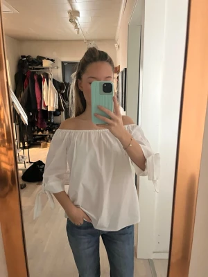 Vit offshoulder blus med knyt - Säljer en vit offshoulder blus med trekvartsärmar och knytband vid ärmsluten. Alldrig använt, lappen från sellpy kvar! 