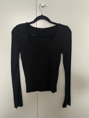 Svart långärmad tröja - Svart långärmat tröja från Gina Tricot med utsvängda ärmar med slits. Storlek XS, använd men i fint skick