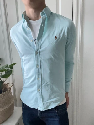 Ralph Lauren skjorta  - Ralph Lauren skjorta turkos l storlek S slim fit som är lite liten på modellen som är 180 cm 75 kg. Inga defekter! Väldigt najs skjorta! Kom med frågor ✌️