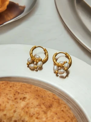 Sötvattenspärlor Örhängen i Stål med 18k Pvd Guld, Vattentålig - BILLIE - Detta eleganta örhängen är tillverkad av rostfritt stål med 18k PVD-guldplätering. Smycket är hypoallergent och vattentåligt – perfekt för daglig användning, även i dusch, träning eller på resa och är lämpliga även för känslig hud. Smyckets pärlor består av äkta sötvattenspärlor. Varje pärla är unik – eftersom de är naturliga har de variationer i form och yta och vissa kan ha svagt gulaktiga nyanser.Huvudmaterial: Rostfritt stål Plätering: 18K Pvd Guldplätering Pärlor: Äkta sötvattenspärlor Vikt