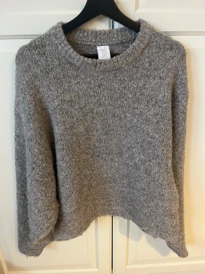 Grå stickad tröja från Soft Rebels - Mysig grå stickad tröja från Soft Rebels med avslappnad passform och rund halsringning. Perfekt för lager-på-lager och har en lite längre ärm för extra komfort. Enkel och stilren design som funkar till det mesta.