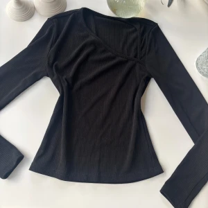 Assymmetrisk ribbad tröja - I nyskick och liknande den på andra bilden. Tror den är från märket Stockholm och passar XS/S❤️Snygg svart ribbad med lång ärm och asymmetrisk halsringning. Toppen har en slim passform och är tillverkad i mjuk, stretchig bomull som sitter skönt mot kroppen. 