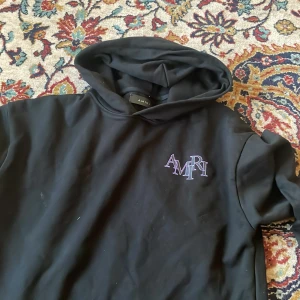 Svart hoodie från Amiri med lila tryck - skön kofta men har knappt på mig så vill ba få bort, garanterar inte äkthet