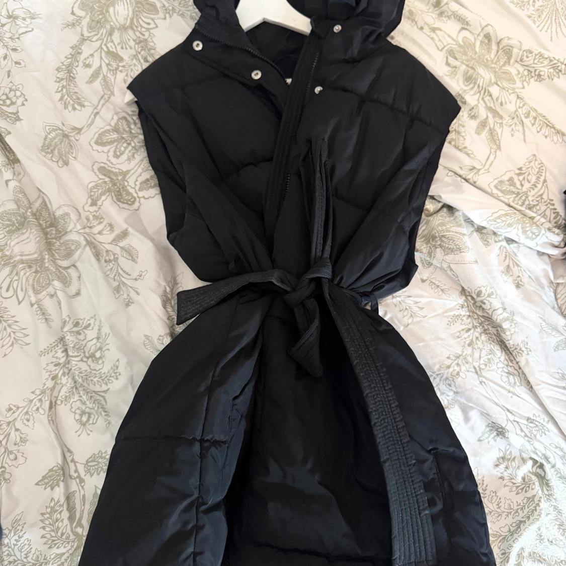 Svart quiltad dunväst med luva