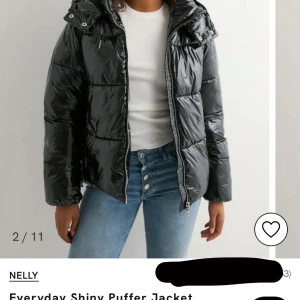 Svart glansig pufferjacka från Nelly - Säljer en svart, glansig pufferjacka från Nelly i storlek XS. Jackan har huva, dragkedja framtill och quiltad design. Perfekt för kalla dagar när du vill ha en snygg och trendig look. Materialet är syntet och jackan är långärmad.💓💓(Pris kan diskuteras!)