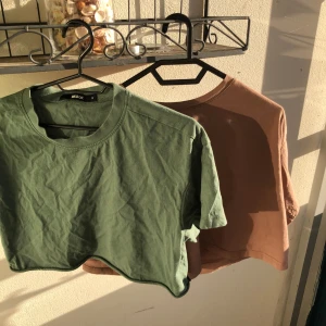 2 croppade t-shirts  - Två croppade t-shirts en i mörkgrönt och en i brunt. Båda är korta vid magen men har lös passform . dom passar S-L (beroende på brösten dock om du har stora bröst kommer ju tröjan bli kortare så man vet innan bara💕). Använda mycket o köpta för längesen men de finns inga tecken på användning förutom i slutet på den gröna så har det ”rullat” upp sig lite vilket syns på bilden men det går säkert att använda strykjärn)+ den gröna är lite kortare äm den bruna💕